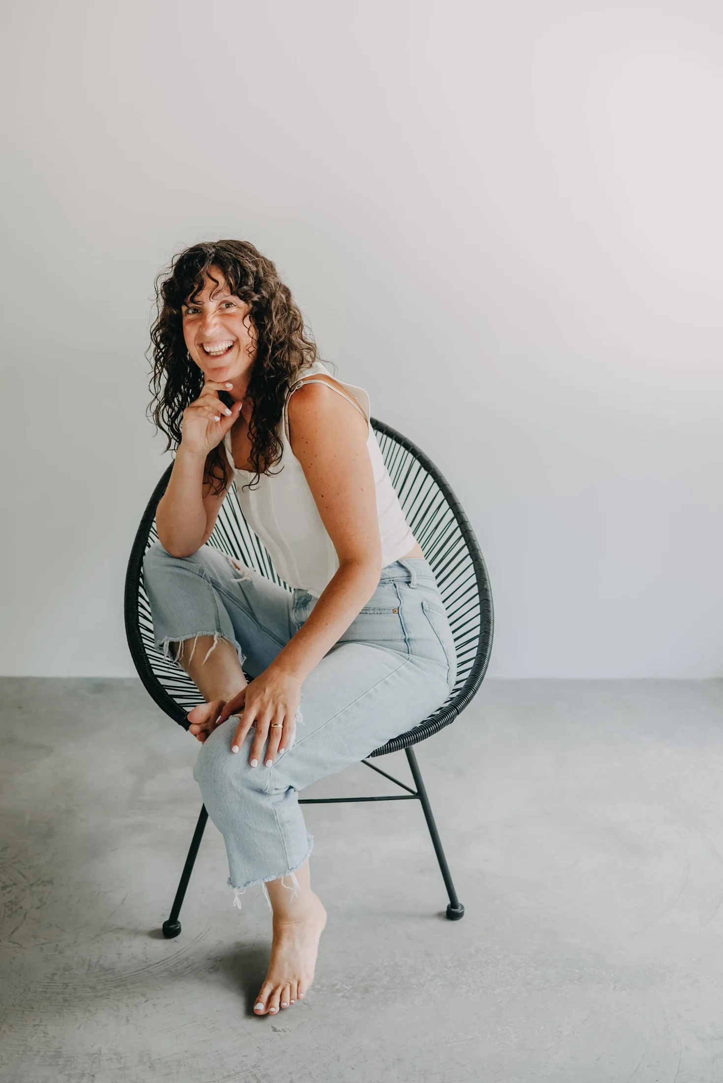Shelby laughing in a relaxed chair, hair loose