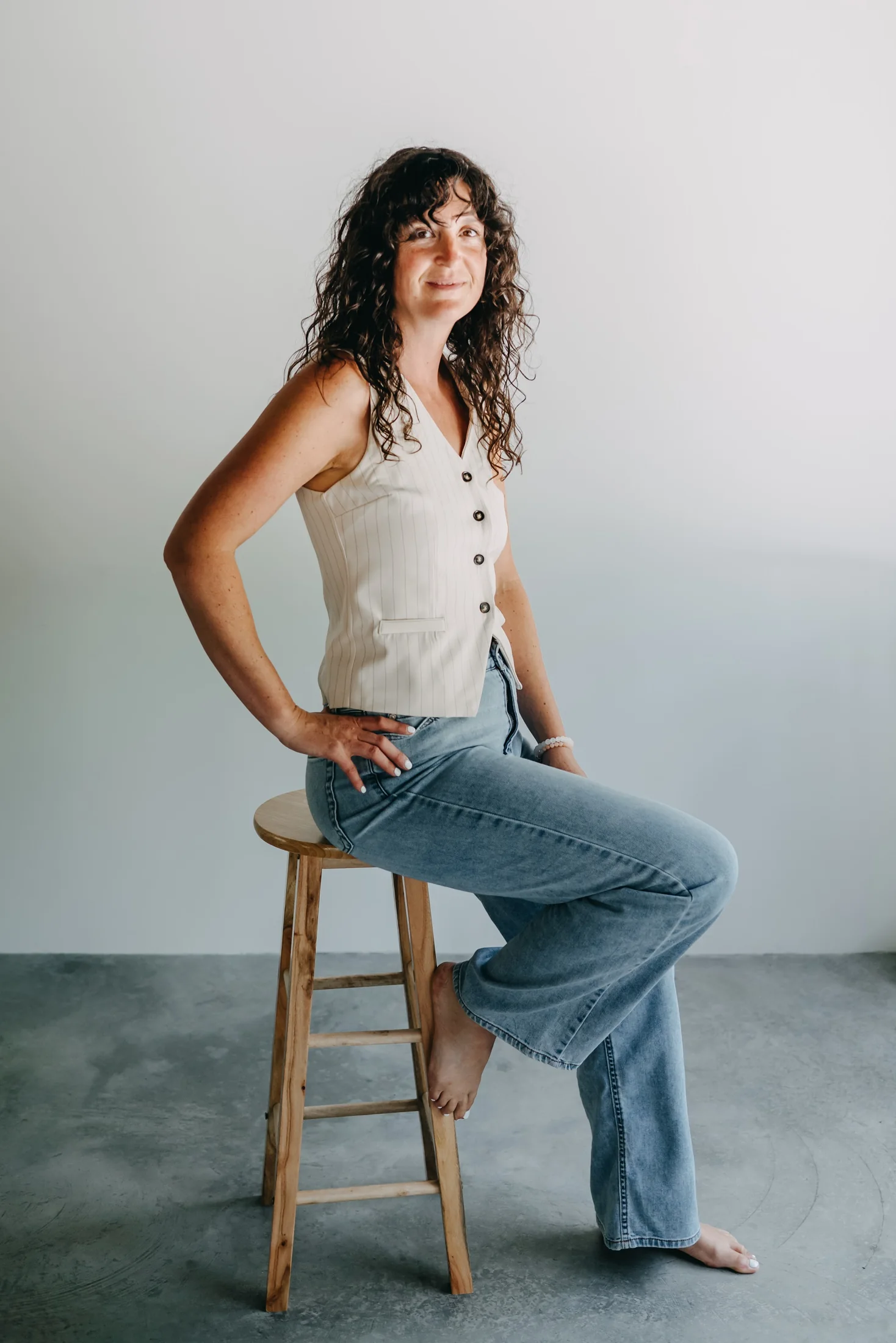Shelby Foster seated on a stool, poised and at ease