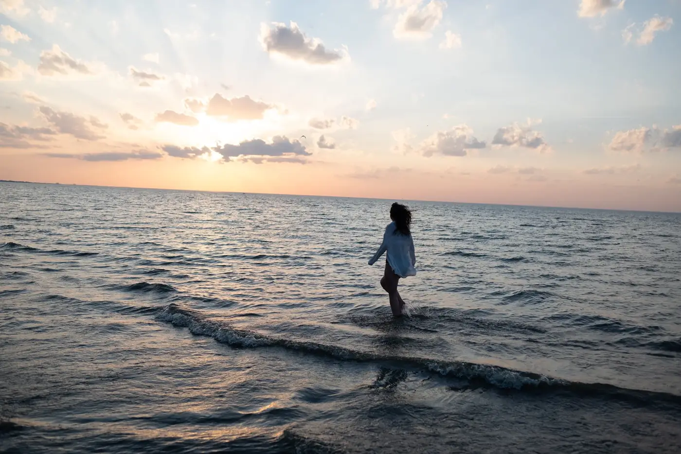 Shelby walking along the shoreline at sunset